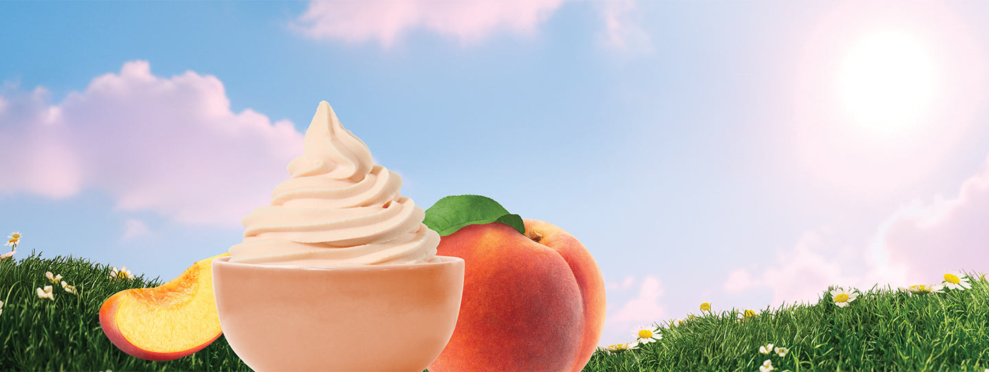 Yogurtland frozen yogurt alongside peaches on a grassy hillside